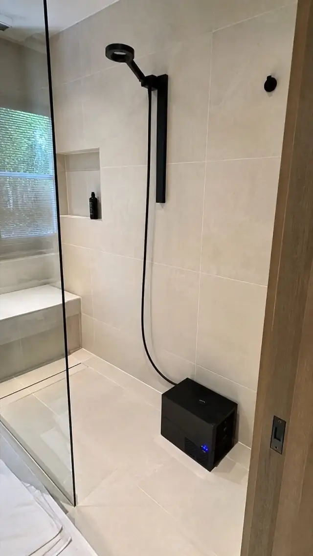 Olsek Ice Shower installed in a light tiled walk-in shower