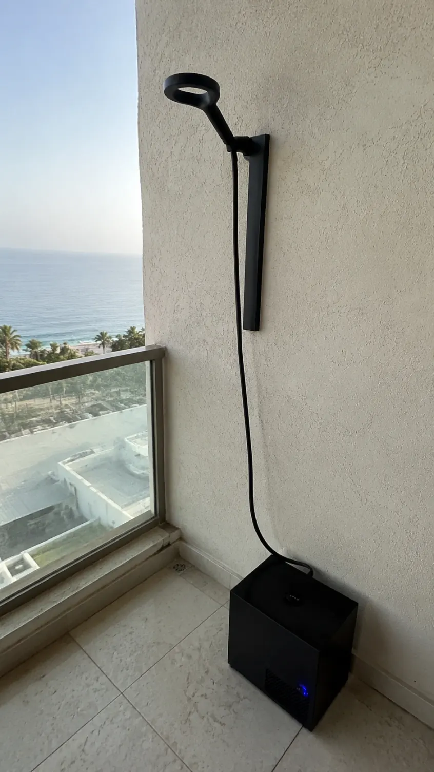 Olsek Ice Shower installed on a compact balcony overlooking the sea